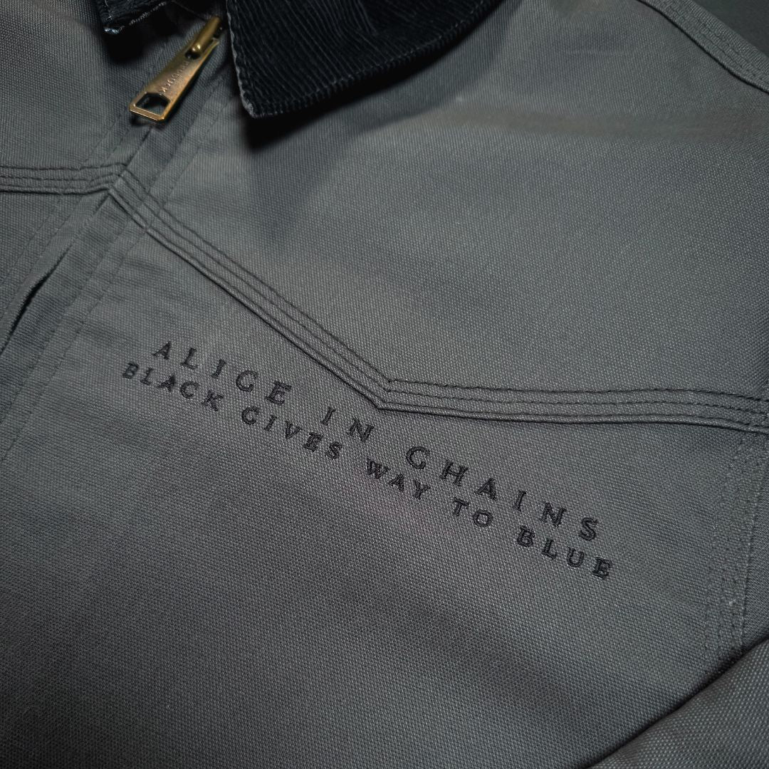 Dark gray canvas work jacket with black alice in chains black gives way to blue embroidery and gold zipper pull