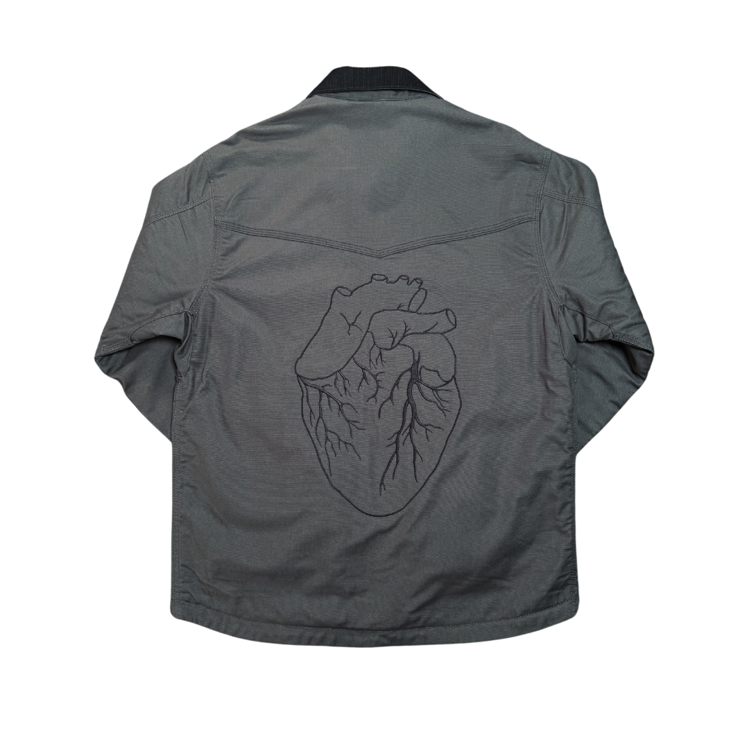 Gray denim work jacket with detailed black embroidered heart design on the back from black gives way to blue collection