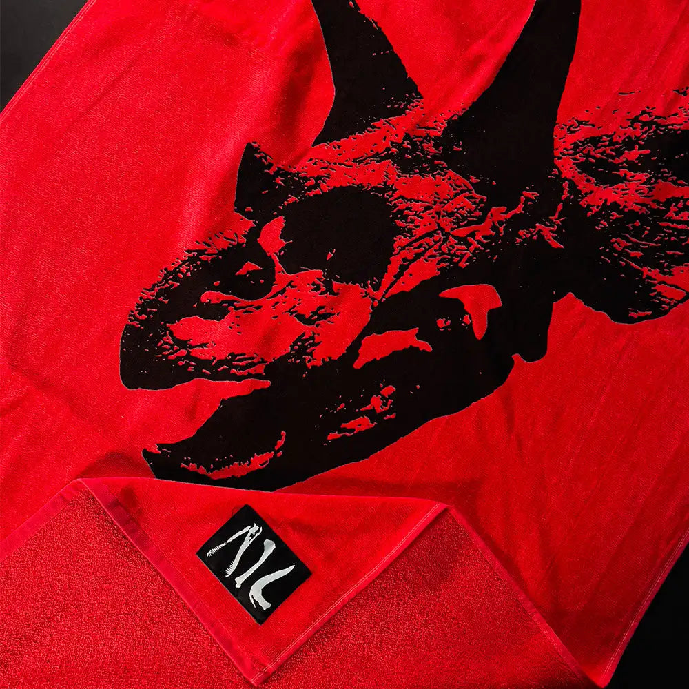 Red towel featuring a bold black graphic of a dinosaur skull.