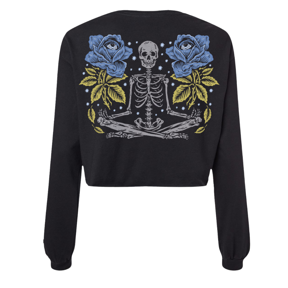 Black cropped sweatshirt featuring a detailed graphic of a skeleton meditating between two blue roses with yellow leaves and starry background.